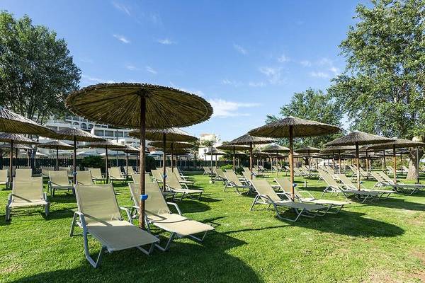 Viele Strandloungesessel und Sonnenschirme im Freien am Dolce Athens Attica Riviera Hotel.