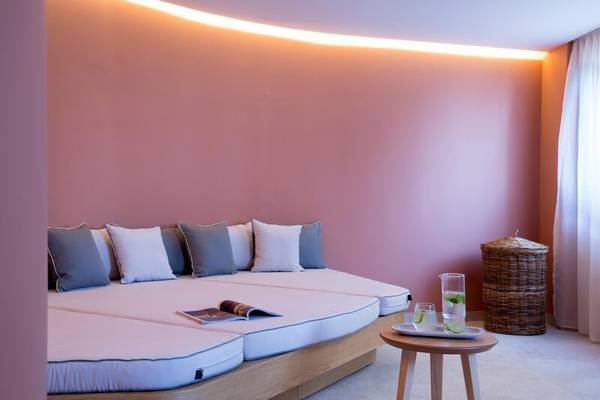 Doppelbett im Dolce Athens Attica Riviera mit Kissen und Tisch mit Getränken.