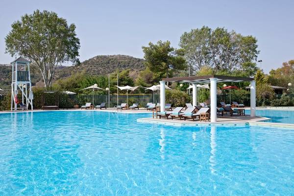 Pool im Dolce Athens Attica Riviera Hotel mit Sonnenliegen und Schirmen.