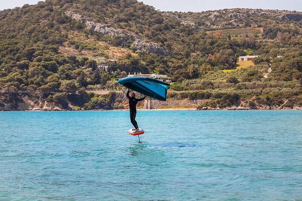 Mann auf Flugbrett im Wasser vor dem Hotel Dolce Athens Attica Riviera
