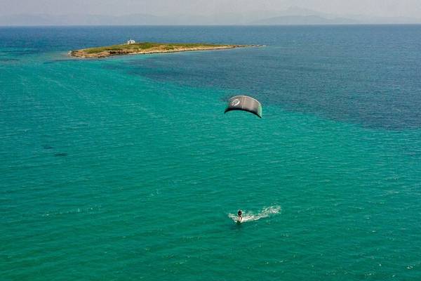Luftbild eines Paraseglers im Meer vor einer Insel, Hotelname Dolce Athens Attica Riviera