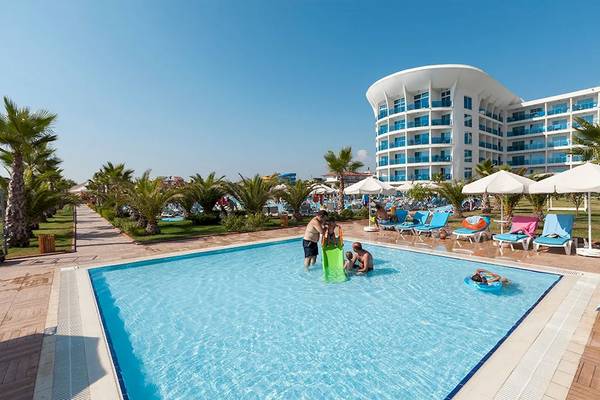 Außenpool des Sultan of Dreams Hotels mit mehreren Gästen und einem Hotelgebäude im Hintergrund.