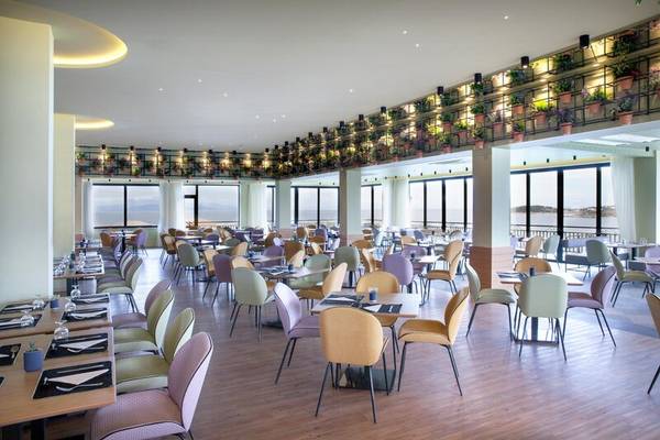 Innenbereich des Restaurants im Dolce Athens Attica Riviera mit Blick auf das Meer.