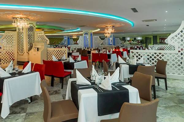 Innenansicht des Sultan of Dreams Restaurants mit gedeckten Tischen und blauer Beleuchtung.