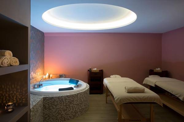 Wellnessbereich im Dolce Athens Attica Riviera mit Whirlpool, Massageliegen und beleuchteter Decke.