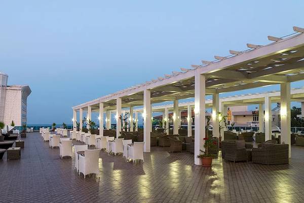 Außenterrasse des Sultan of Dreams Hotels mit weißen Stühlen und Tischen unter einer Pergola
