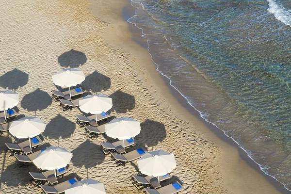 Luftaufnahme des I Resort Beach Hotel & Spa Strands mit Sonnenliegen und Schirmen