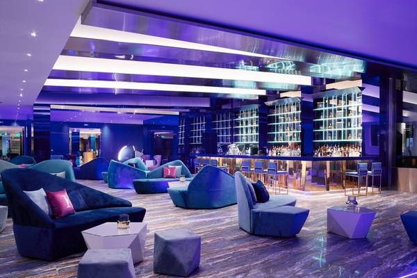 Lounge-Bereich des I Resort Beach Hotel & Spa mit blauen Möbeln und einer Bar.