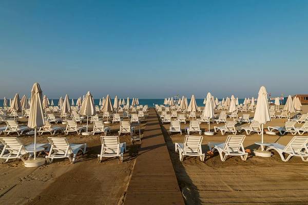 Strand mit weißen Liegestühlen und Sonnenschirmen im Sultan of Dreams Hotel
