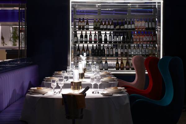 Innenansicht des Restaurants im I Resort Beach Hotel & Spa mit Tisch und gefülltem Weinregal.