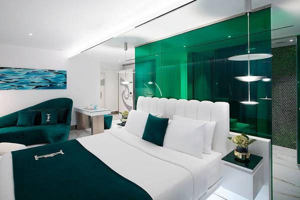 Schlafzimmer im I Resort Beach Hotel & Spa mit grünen Wänden, weißen Möbeln und blauen Akzenten.