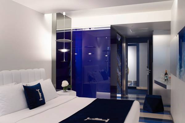 Schlafzimmer im I Resort Beach Hotel & Spa mit weißem Bett, blauen Akzenten und moderner Einrichtung.