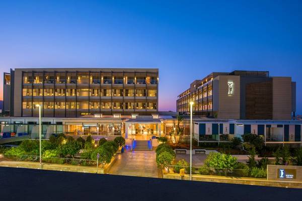 Abendansicht des I Resort Beach Hotel & Spa mit beleuchteten Gebäuden und gepflasterten Wegen.