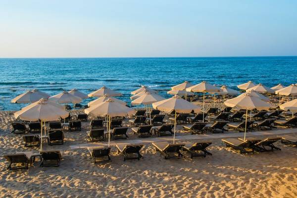 Foto von einer Reihe von Sonnenliegen und Sonnenschirmen am Strand des I Resort Strand Hotel & Spa
