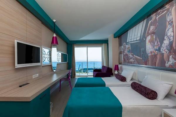 Hotelzimmer mit zwei Betten, Schreibtisch, Fernseher und Meerblick