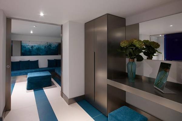 Innenbereich des I Resort Beach Hotel mit blauen Möbeln, einem Schrank und einem Tisch mit Blumen.