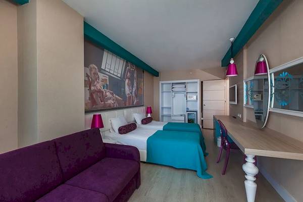 Suite-Zimmer im Sultan of Dreams Hotel mit zwei Betten, einem Sofa und einem Schreibtisch.