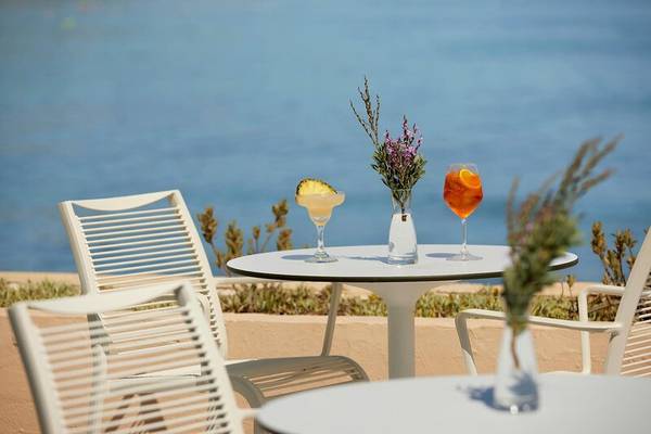 Terrasse des I Resort Beach Hotel & Spa mit Getränken und Blick aufs Meer