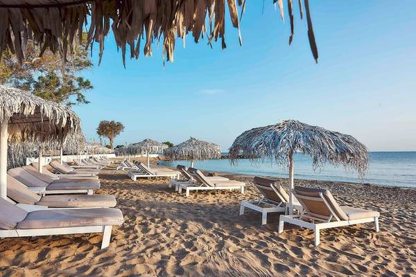 Strand des Nema Design Hotels & Spa mit vielen Liegestühlen und Sonnenschirmen