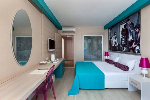 Suite-Zimmer im Sultan of Dreams Hotel mit Bett, Schreibtisch und Lampe.