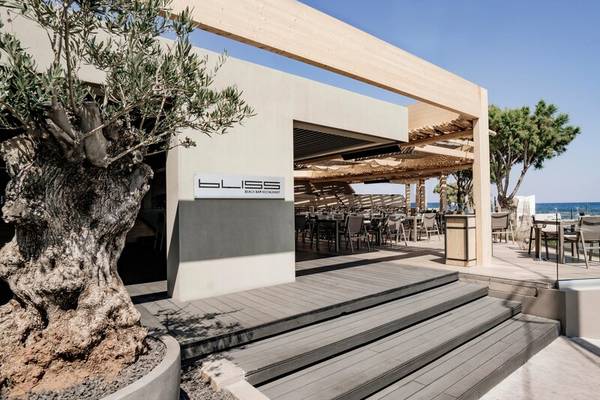 Strandbar des Nema Design Hotel & Spa mit Tischen und Stühlen im Freien.