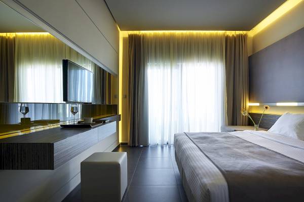 Schlafzimmer im Nema Design Hotel & Spa mit Bett, Fernseher und Lampe.