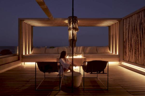 Frau auf der Terrasse des Nema Design Hotels und Spas am Abend.