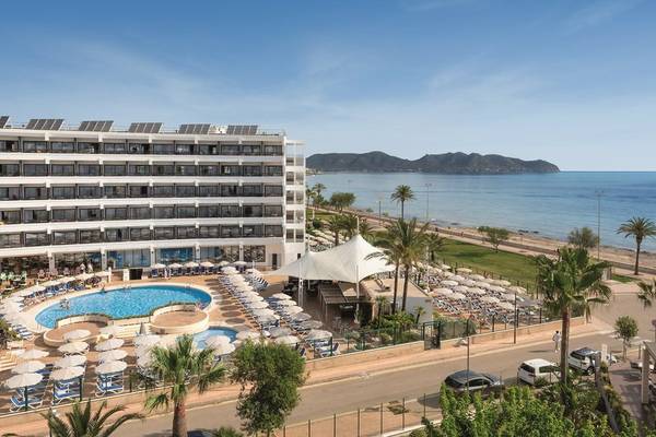 Außenansicht des Allsun Hotel Sumba mit Pool, Sonnenschirmen und Meer im Hintergrund.