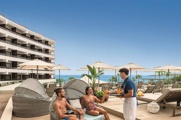 Hotelterrasse des Allsun Hotel Sumba mit Blick auf das Meer und Loungebereich mit Gästen