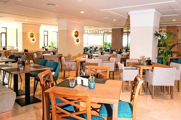 Innenansicht des Restaurants im Allsun Hotel Sumba mit runden Tischen und Stühlen.