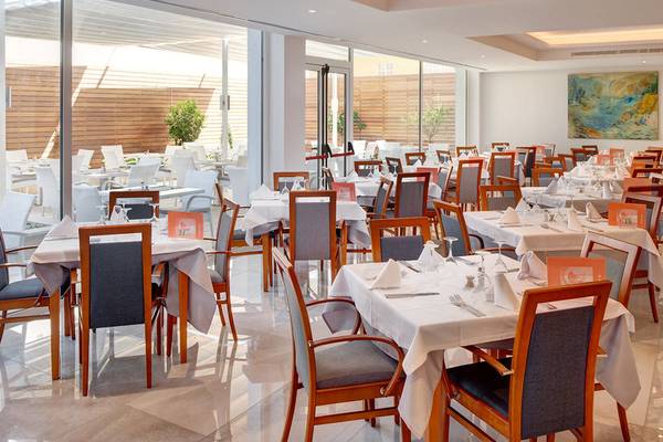 Innenansicht des Girasol Hotel Restaurants mit gedeckten Tischen und einer großen Glasfassade.