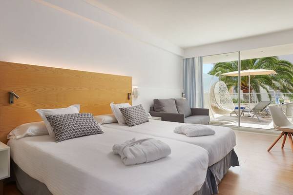 Doppelzimmer im Girasol Hotel mit zwei Betten, weißem Bettwäsche und einem Balkon