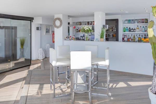 Barbereich des Aparthotels Marins Playa mit weißen Stühlen und Theke