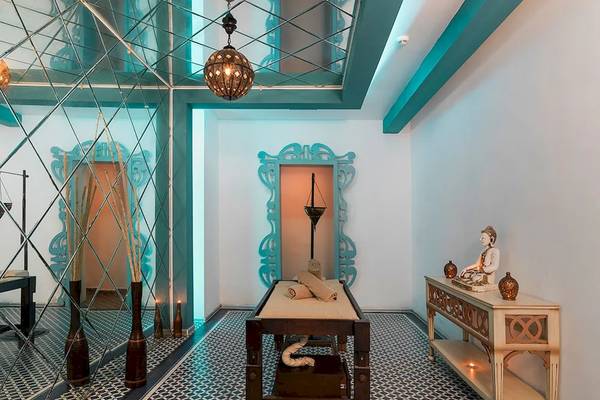 Behandlungsraum im Sultan of Dreams Hotel Spa mit Liege, Tisch, Buddha-Statue und blauen Wandverkleidungen.