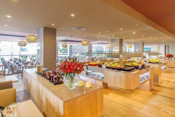 Buffetbereich des Aparthotel Marins Playa mit Tisch, Stühle und Blumenarrangement.
