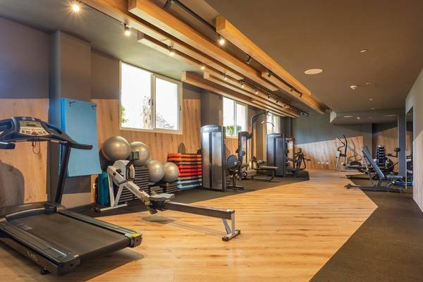 Fitnessraum im Aparthotel Marins Playa mit Laufband, Gewichten und Geräten.