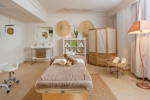 Massageraum im Aparthotel Marins Playa mit zwei Massagetischen, Stühle und Lampen.