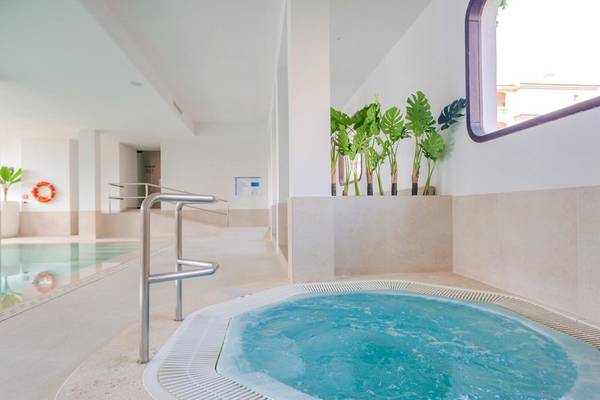 Whirlpool im Aparthotel Marins Playa mit Blick auf den Pool und Pflanzen.