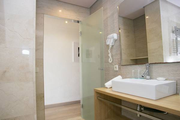 Ein Badezimmer mit einer Dusche, einem Waschbecken und einem Spiegel im Aparthotel Marins Playa.