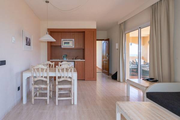 Esszimmer im Aparthotel Marins Playa mit Tisch, Stühlen und offener Küche
