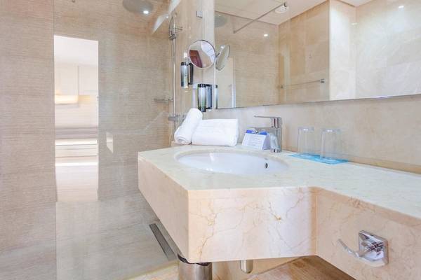 Badezimmer im Aparthotel Marins Playa mit Glasdusche, Waschbecken und Toilettenartikeln