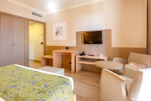 Hotelzimmer im Aparthotel Marins Playa mit Bett, Fernseher und Möbeln.