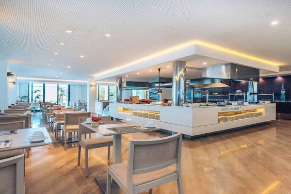 Innenansicht des Restaurants im Iberostar Cala Millor Hotel mit modernen Möbeln und Holzboden.