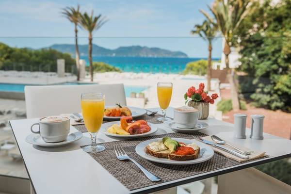 Frühstück auf der Terrasse des Iberostar Cala Millor Hotels mit Blick auf den Pool und das Meer.