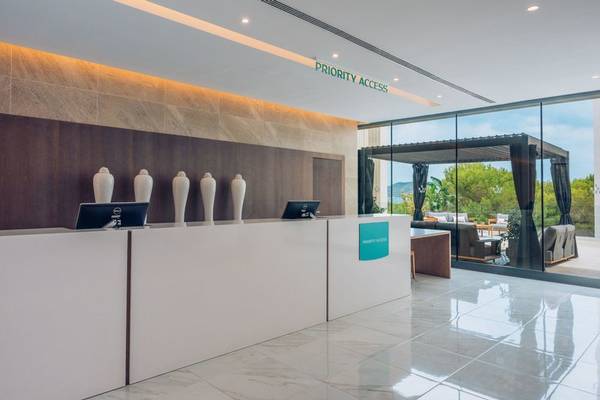 Empfangsbereich des Iberostar Cala Millor Hotels mit moderner Rezeption und großen Fenstern.