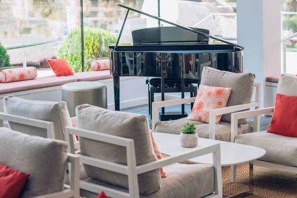 Hotellounge mit Klavier im Iberostar Cala Millor mit Sitzgelegenheiten und Pflanzen