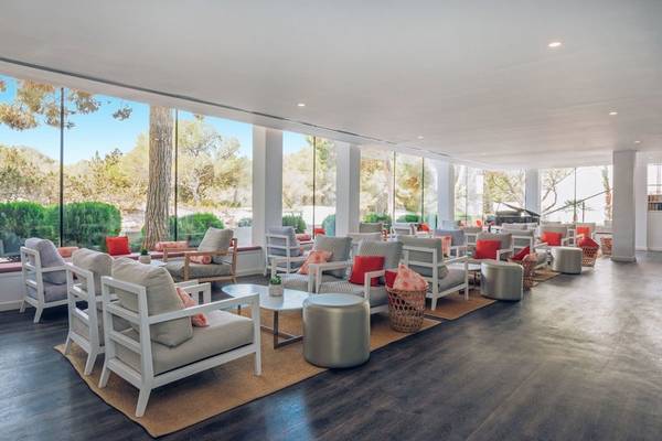 Loungebereich des Iberostar Cala Millor Hotels mit weißen Möbeln und großen Fenstern.