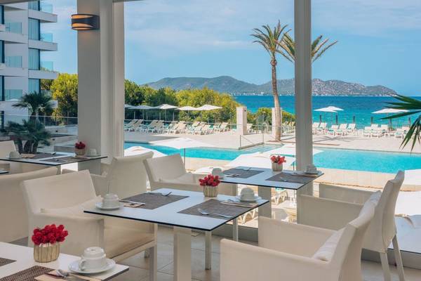 Innenpool-Terrasse des Iberostar Cala Millor Hotels mit Blick auf das Meer und Palmen