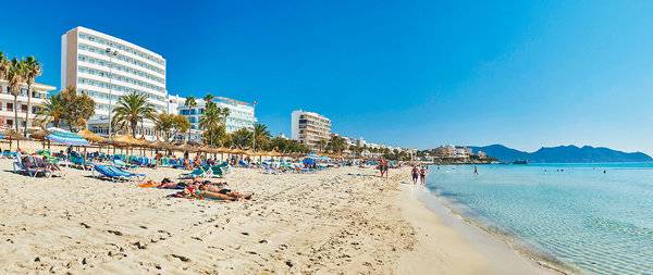Strand mit Hotelanlage Hipotels Don Juan und Sonnenschirmen, Liegen und blauem Himmel