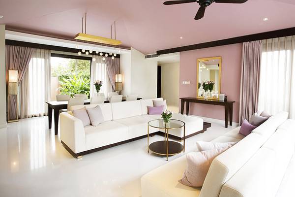 Wohnbereich im TIA Wellness Resort mit zwei weißen Sofas und einem Tisch mit Blumenvase.